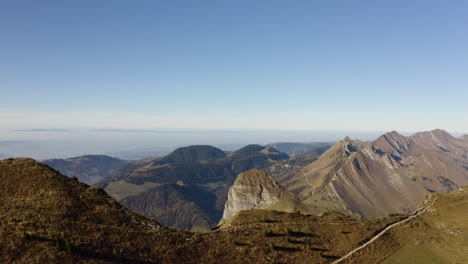 Flying-along-ridge,-parallax-effect-with-summits-in-the-background-Rochers-de-Naye,-Prealps---Switzerland-with-autumn-colors