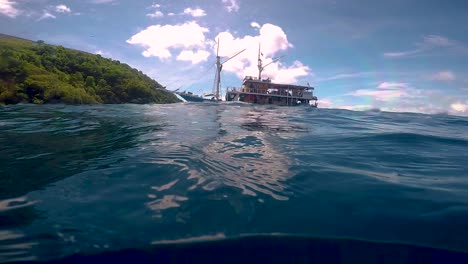 Long-clip-in-slow-motion-of-a-girl-who-freedives-under-a-wooden-boat-in-Indonesia