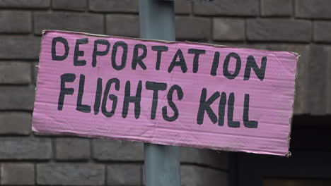 UK-February-2019---A-pink-placard-taped-to-a-lamp-post-that-says,-â€œDeportation-Flights-Killâ€-flutters-in-the-wind