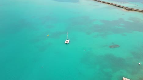 Vista-Aérea-Del-Velero-En-Aguas-Turquesas-Por-Isla-Tropical