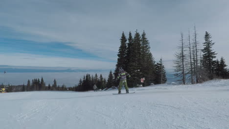 Two-snowboarders-travelling-off-downhill-on-white-snowy-slopes-into-distance