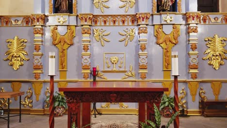 Blick-Auf-Einen-Missionsaltar-Mit-Kerzen-Auf-Der-Ätherseite-Und-Goldenem-Religiösem-Dekor-An-Den-Wänden