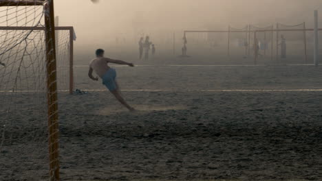 Macho-Joven-Pateando-Fútbol-En-El-Aire-Con-Una-Patada-De-Tijera-Mientras-Una-Densa-Niebla-Marina-Cubre-El-Campo