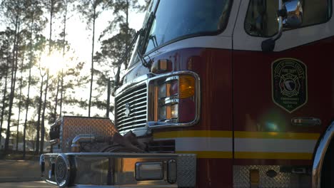 Fire-engine-sits-shiny-outside-of-a-fire-station-in-the-early-morning-sunlight