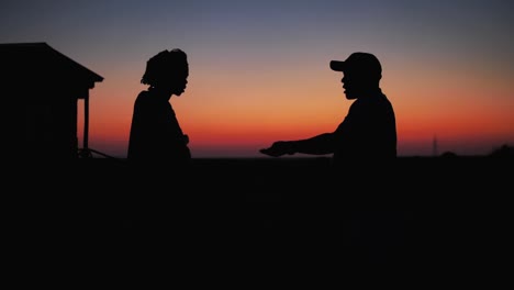 Silhouette-Eines-Farmbesitzers,-Der-Landarbeiter-Nach-Einem-Tag-Arbeit-Am-Bauernhaus-Im-Morgengrauen-Bezahlt