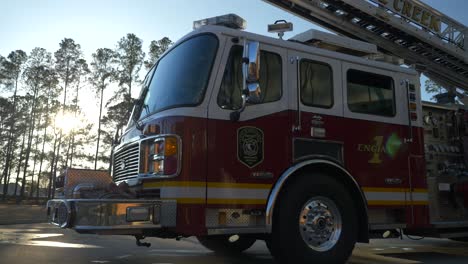 Fire-engine-sits-shiny-outside-of-a-fire-station-in-the-early-morning-sunlight