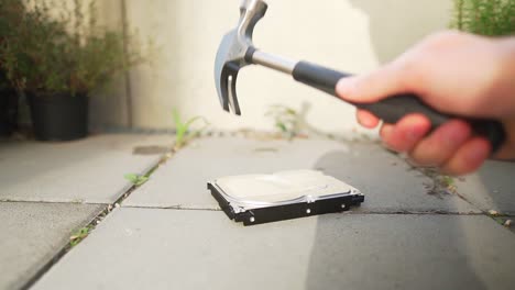 Slow-motion-clip-of-man-destroying-a-hard-drive-with-a-hammer