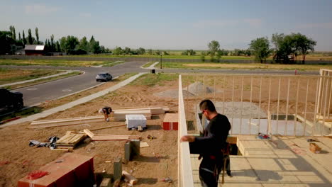 A-drone-shot-floating-around-the-construction-framers-putting-up-walls-on-a-new-home-in-the-process-of-being-built