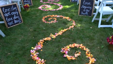 Hochzeitsgang-Im-Garten-Vor-Dem-Gottesdienst,-Geschmückt-Mit-Blütenblättern-Im-Wirbelmuster-Und-Bibelversen