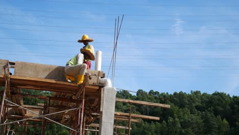 Bauarbeiter,-Die-Auf-Der-Baustelle-Holzschalungen-Und-Regenwasserrohre-Installieren