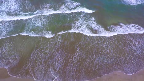 Bird´s-eye-view-of-the-coastline-Boca-del-Rio-beach,-image-from-the-heights-of-how-the-beach-looks,-with-serene-waves-and-white-sand,-the-umbrellas-accompany-the-coming-and-going-of-the-sea