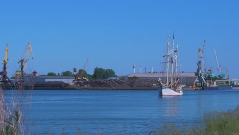 El-Velero-Zawisza-Czarny-Sale-Del-Puerto-De-Liepaja-En-Un-Caluroso-Día-Soleado-De-Verano,-Plano-Medio-Desde-La-Distancia