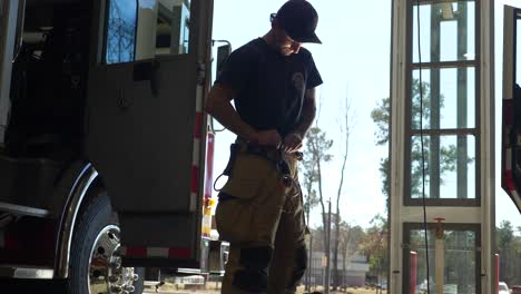 Bombero-Se-Pone-Pantalones-Protectores-De-Extinción-De-Incendios-Mientras-Se-Prepara-Para-Responder-A-Una-Emergencia