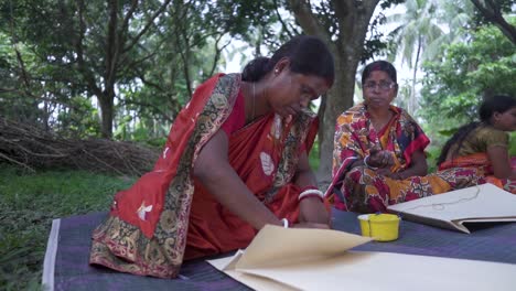 Poor-Indian-women-folding-and-making-bags-outdoor