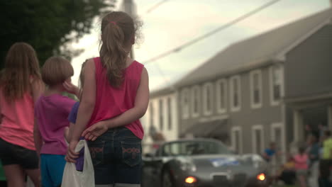 Children-standing-on-sidewalk-waiting-for-candy-from-parade