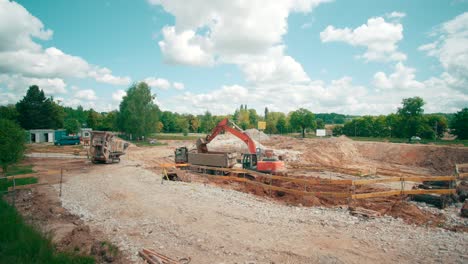 Blick-Auf-Schwere-Maschinen,-Die-Auf-Einer-Baustelle-Arbeiten-Und-Den-Kies-In-Einen-Muldenkipper-Laden