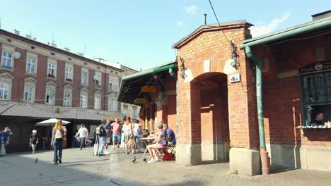 People-buying-street-food-at-Jewish-market-at-Plac-Nowy-jewish-square-in-Krakow,-Pan-shot