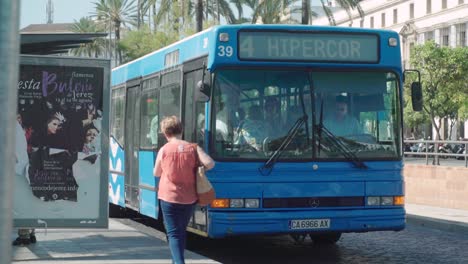 Spanierin-Läuft-Auf-Bus-Zu,-Steigt-Ein,-Bus-Fährt-Weg,-Zeitlupe