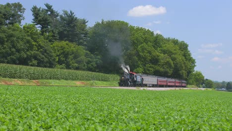 Ein-Zeitraffer-Einer-Dampflokomotive-Aus-Dem-Jahr-1910-Mit-Einem-Personenzug,-Der-An-Einem-Sonnigen-Sommertag-Entlang-Der-Amish-Landschaft-Wartet