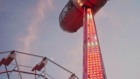 Karnevalsfahrt-Stoppte-Am-Himmel-Mit-Riesenrad-Und-Mond-Im-Hintergrund,-Zeitlupe