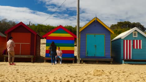 Tourists-walking-and-taking-photo-at-Brighton-Bathing-Boxes,-Melbourne,-Australia