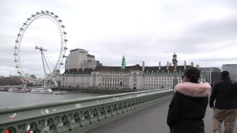 Ein-Paar-Besucher-Fotografieren-Vor-Dem-Millennium-Wheel-Des-London-Eye-Auf-Der-Westminster-Bridge,-Einen-Tag-Nachdem-Der-Britische-Premierminister-Boris-Johnson-Davor-Gewarnt-Hatte,-Wegen-Des-Coronavirus-Ausbruchs-Zu-Hause-Zu-Bleiben