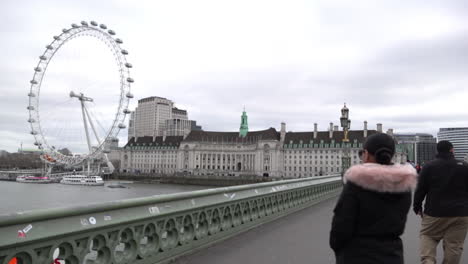 Algunos-Visitantes-Toman-Fotografías-Frente-A-La-Rueda-Del-Milenio-Del-Ojo-De-Londres-En-El-Puente-De-Westminster-El-Día-Después-De-Que-El-Primer-Ministro-Del-Reino-Unido,-Boris-Johnson,-Advirtiera-De-Quedarse-En-Casa-Debido-Al-Brote-De-Coronavirus