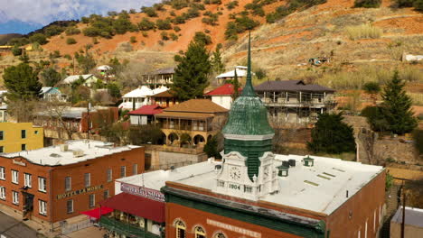 El-Icónico-Castillo-Pythian-En-Bisbee,-Arizona,-Con-Su-Reconocible-Torre-De-Reloj-Verde-Y-Aguja---Disparo-De-Drones