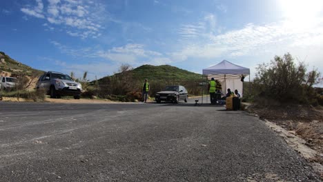 Equipos-De-Boxes-Inspeccionando-Los-Autos-Que-Pasan-Por-La-Parada-En-Boxes-En-La-Colina-En-Imtahleb-Malta-En-Un-Día-Caluroso-Y-Soleado---Gopro-Timelapse