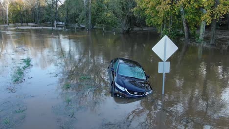 Sedán-Honda-Civic-Azul-Varado-En-Un-Río-Inundado,-Punto-De-Interés-Aéreo