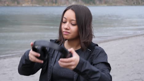 Woman-on-the-shore-of-a-mountain-lake-starts-listen-to-music-on-her-headphones