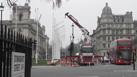 Arbeiter-Installieren-Fahnenmast-In-Den-Gärten-Des-Parlamentsplatzes,-Während-Ein-Londoner-Bus-Vorbeifährt