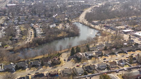 An-aerial-shot-of-a-pond-in-a-suburban-neighborhood-on-Long-Island,-NY