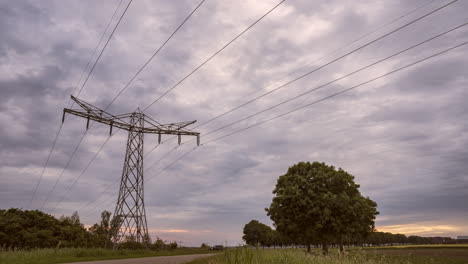 Strommast-Bei-Sonnenuntergang-Mit-Sich-Schnell-Bewegenden-Wolken,-Die-Richtung-Und-Farbe-ändern