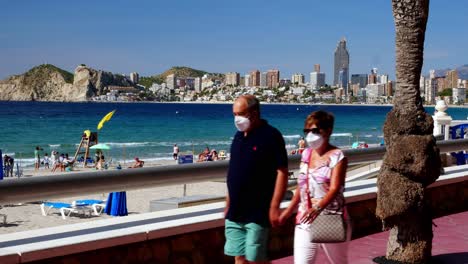 Gesperrte-Aufnahme-Von-Touristen,-Die-Trotz-Coronavirus-Und-Schutzmasken-Das-Wetter-In-Benidorm-Genießen