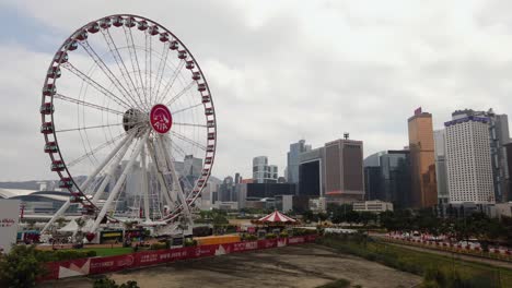 Rueda-De-Observación-De-Hong-Kong-Y-Parque-De-Vitalidad-Aia-Con-Rascacielos-De-La-Ciudad-En-El-Fondo