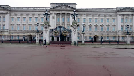 Toma-En-Cámara-Lenta-De-Dos-Personas-Corriendo-Justo-En-Frente-Del-Famoso-Palacio-De-Buckingham,-Londres