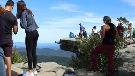 Ein-Mann-Zeigt-Seinem-Sohn,-Wo-Er-Sich-Für-Ein-Foto-Am-Mcafee-Knob-Hinsetzen-Soll