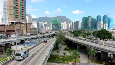 área-Urbana-De-Kowloon-En-El-Centro-De-Hong-Kong,-Vista-Aérea-De-ángulo-Bajo-Con-Tráfico-Y-Rascacielos-De-La-Ciudad