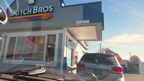 Vehicle-Waiting-In-Drive-Thru-Lane-To-Order-Coffee-At-Dutch-Bros-Coffee-In-Brookings,-Oregon---handheld