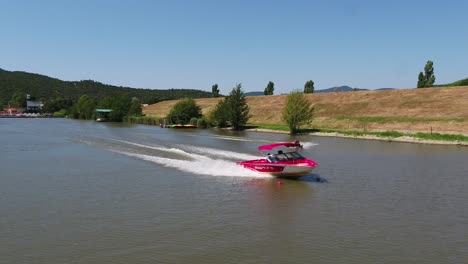 Luftaufnahme-Einer-Person,-Die-Hinter-Einem-Boot-Wakeboard-Fährt---Zeitlupe,-Drohnenaufnahme