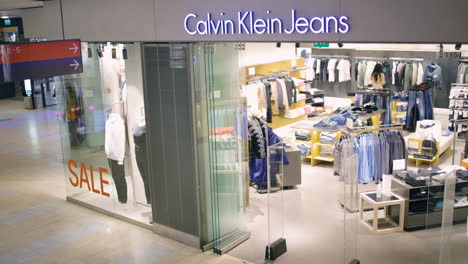 La-Gente-Camina-Por-La-Tienda-De-Jeans-Calvin-Klein-En-El-Centro-Comercial,-Slomo-Desde-Arriba