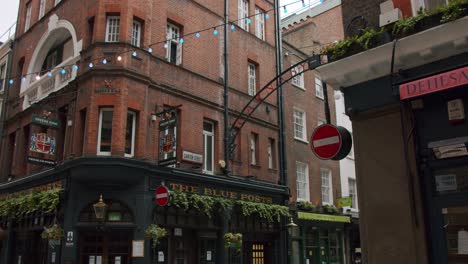 Stunning-smooth-slow-motion-gimbal-pan-revealing-London-Carnaby-Street's-sign-in-front-of-pub