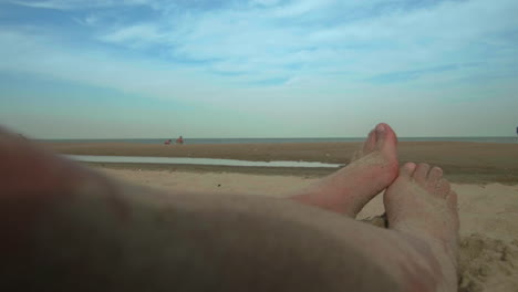 Frau-Mit-Sandigen-Zehen-Sitzt-Im-Sommer-Am-Strand,-Zeitlupe