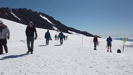 People-walking-and-hiking-on-the-top-of-Europe-in-Switzerland-showing-tourism-is-open