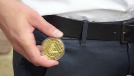 Der-Junge-Geschäftsmann-Holt-Einen-Physischen-Goldenen-Litecoin-Aus-Seiner-Tasche