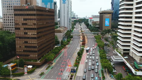 Antena-Cinematográfica-Hacia-Adelante-Sobre-El-Centro-De-La-Ciudad-Calle-Concurrida-Y-Tráfico-De-Automóviles,-Mh-Thamrin