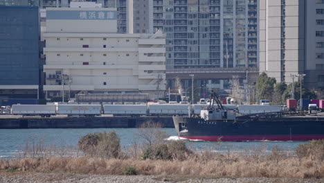 Buque-De-Carga-Que-Pasa-Por-Un-Almacén-De-Fabricación-Frente-Al-Mar-En-La-Bahía-De-Tokio-En-Japón