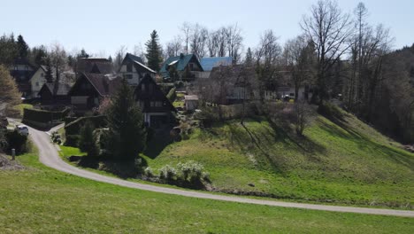 Una-Amplia-Filmación-Aérea-De-Un-Pueblo-Pintoresco-En-Una-Colina-Verde-Con-Arquitectura-Alpina-Tradicional-En-Croacia