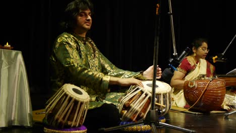 Hombre-Indio-Vestido-Con-Ropa-Tradicional-De-Seda-India-Tocando-Tablas-Con-Los-Dedos-En-El-Escenario